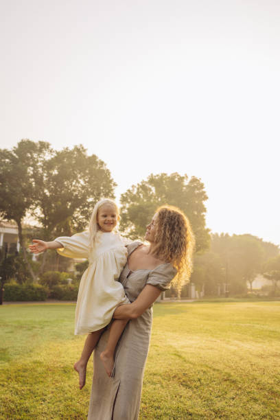istock Mother and daughter dancing in the meadow 2133374703