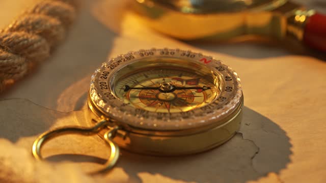 Golden Hour Exploration: Vintage Compass on Antique Map by Seaside