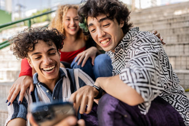istock Young friends using mobile phone outdoors 2133395924
