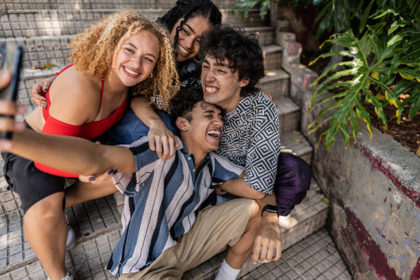 Young friends taking selfie sitting on step outdoors