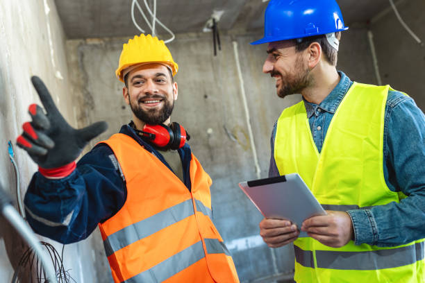 istock Two construction workers working together on the construction site. Visiting new building and planning new work. 2133410216