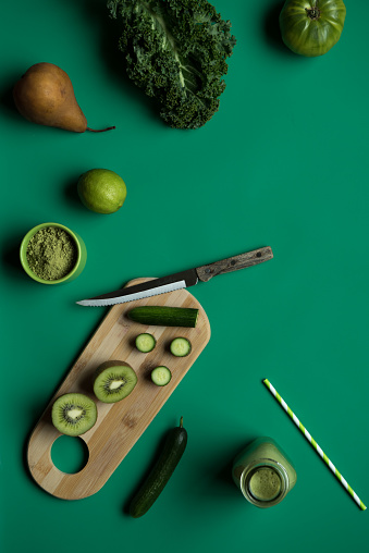 Monochromatic green flay lay of green fruit and vegetable ingredients for a smoothie