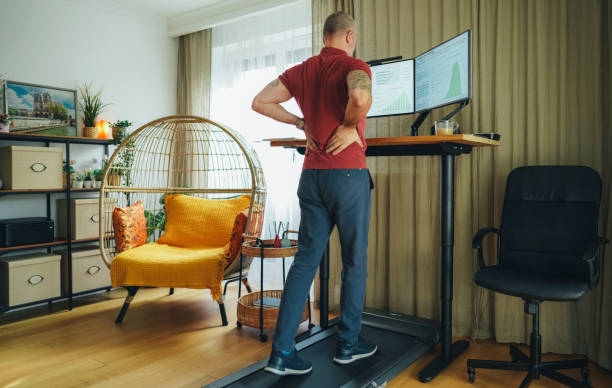 istock Man working from home at standing desk is walking on under desk treadmill 2133418586