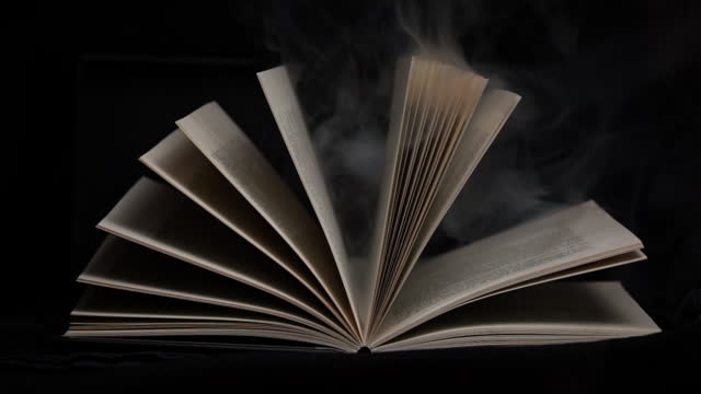 Old Mystical Book with Open Pages with Magic Smoke on Black Background