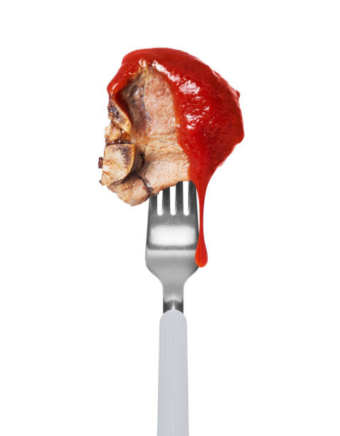 istock Fried beef steak poured with tomato ketchup on a fork close up isolated on a white background 2133445107