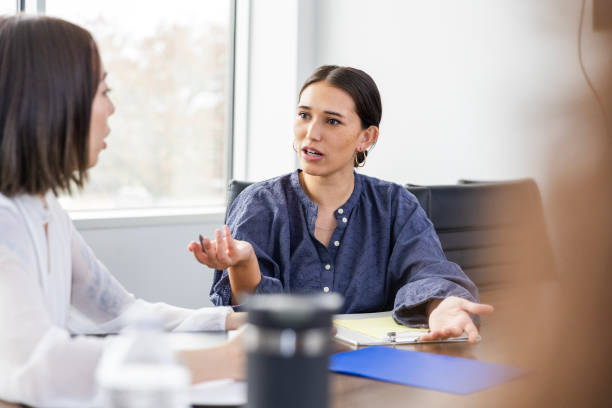istock Two female co-workers disagree during staff meeting 2133473396