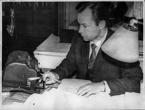 Retro photo of a young scientist making calculations on an adding machine. USSR, 50s of the twentieth century.