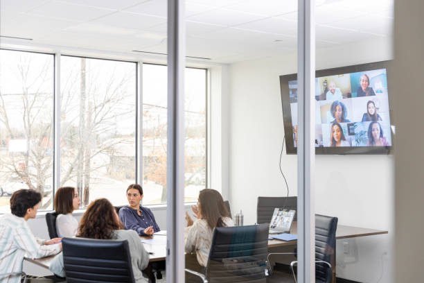 istock Employees in board room discuss business strategy with remote workers 2133502558