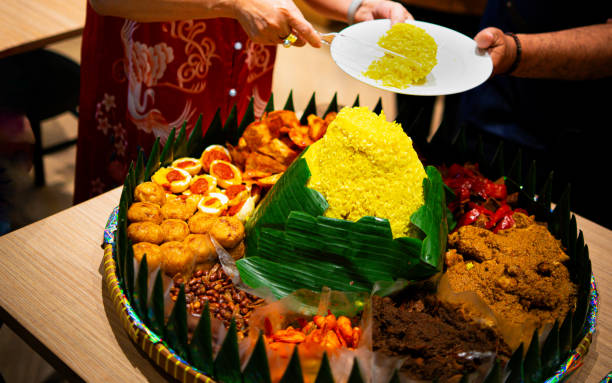 istock A mother was cutting tumpeng yellow rice with various side dishes 2133507842