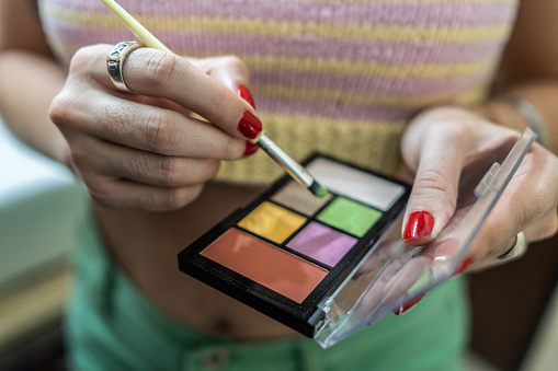 Close-up of a woman holding eyeshadow palette