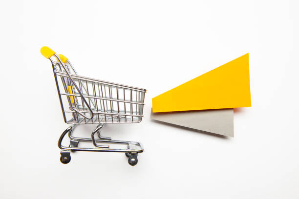 Shopping cart and papers on white background.