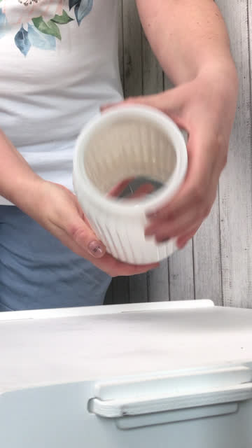 A woman takes out a white glass vase from the package. Makes unpacking and reviewing the purchase. Vertical video.