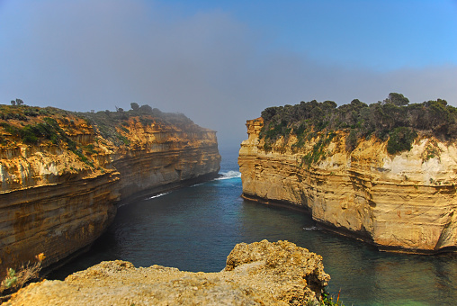The morning fog hangs over the entrance to a small bay along the southern coast of Victoria, Australia.