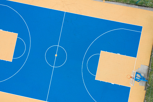 Directly above of the blue and yellow basketball court.