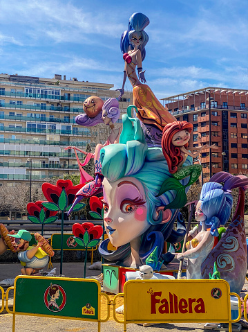 Valencia, Spain - March 15, 2024: Barricaded street with a Ninot in the middle of it. This are huge dolls that are built specifically to be burnt during the last night of Las Fallas annual event, exclusive to the Valencian Community