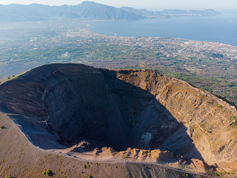 Mount volcano Vesuvius in Napoli. black volcanic sand and volcano texture. in the background the coast with the Tyrrhenian Sea and villages near the volcano