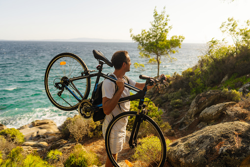 Photo of a man exploring the coastline on a bicycle