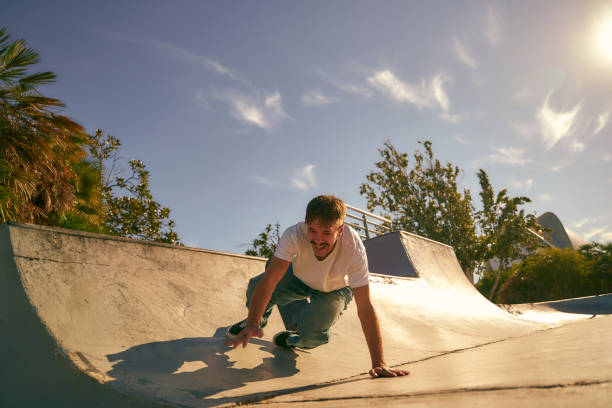 istock Young man fell off his skateboard while doing a trick in skate park on sunny day. Extreme sport concept 2133639170