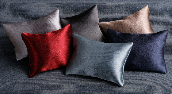 Lot of silk pillows  on dark gray sofa