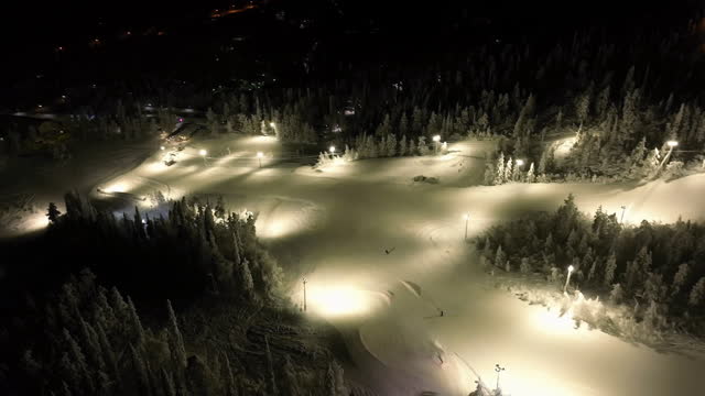 Aerial view circling the night lit slopes of Salla, winter in Lapland, Finland