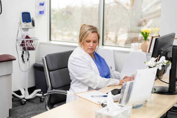 istock Female doctor updates electronic medical records on desktop PC 2133675557