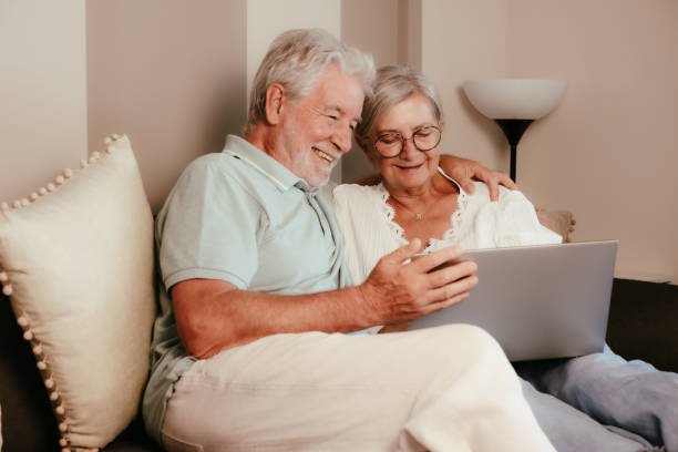 istock Happy bonding loving elderly senior retired couple sitting on sofa, using laptop technology, enjoying carefree moments together in good mood planning travel 2133691515