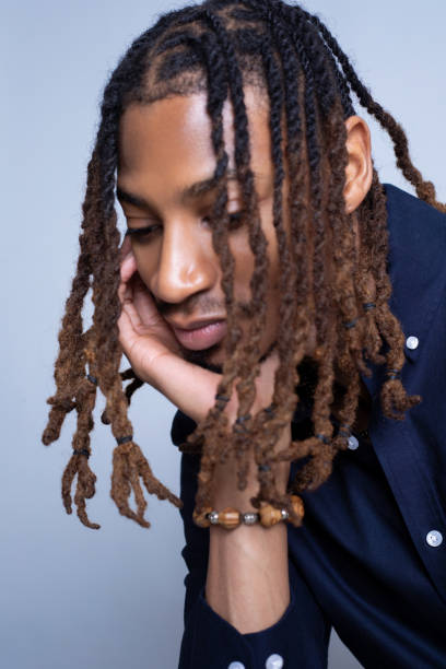 istock African-American man in professional attre with locs in face while looking down 2133695821