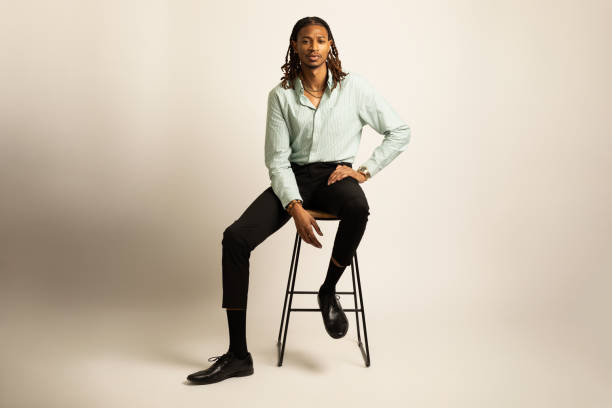 African-American man with locs sitting on stool