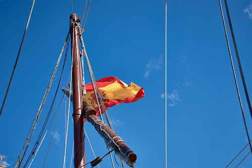 Mast with the flag of Spain of the replica of the caravel Santa Maria docked in Baiona, Pontevedra, Spain