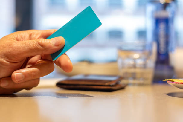 istock A man's hand on the restaurant table holding a credit card. 2133735322