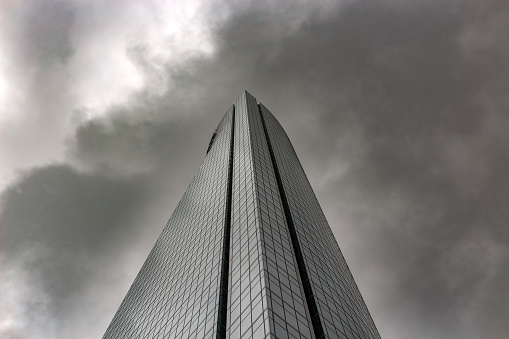 Madrid, Spain. Low angle view of an amazing glass skyscraper against a dramatic cloudy sky.