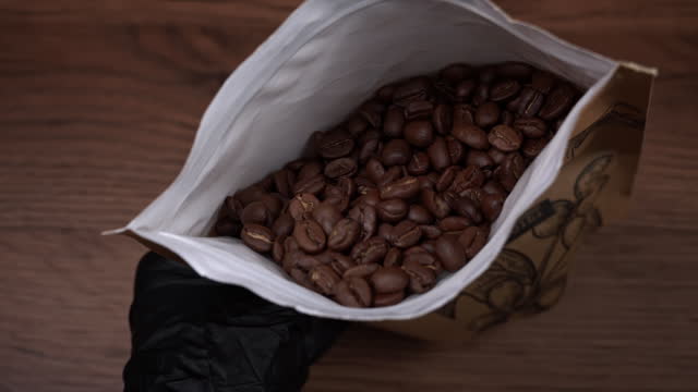 Coffee Beans in Craft Packaging in Human Hands