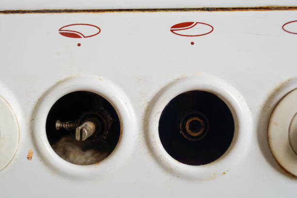 Knobs turning on burners on an old gas stove close-up