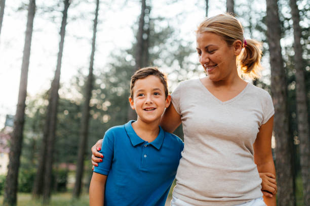 istock Mother embrace her son while walking together in the nature 2133754782