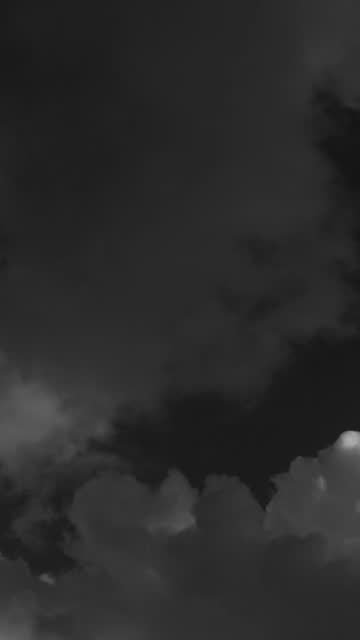 The big powerful storm clouds before a thunder-storm. Black and white. vertical video for social media.