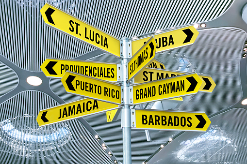 Signs pointing Caribbean touristic cities in an airport terminal