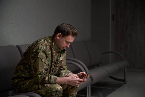 istock Serviceman reading news on his cellular phone in waiting area 2133856475
