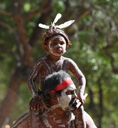 Laura, Qld - July 08 2023:Indigenous Australians father and son on  in Laura Quinkan Dance Festival Cape York Australia. Ceremonies combine dance, song, rituals, body decorations and costumes
