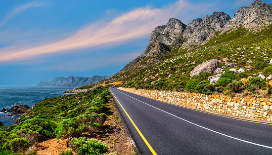 Winding road R44 along indian ocan with lush foliage and rugged mountain at Kogel Bay, Cape Town, South Africa