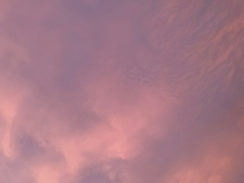 Light and feathery pink morning clouds that look like cotton candy. Beautiful soft abstract pink background.
