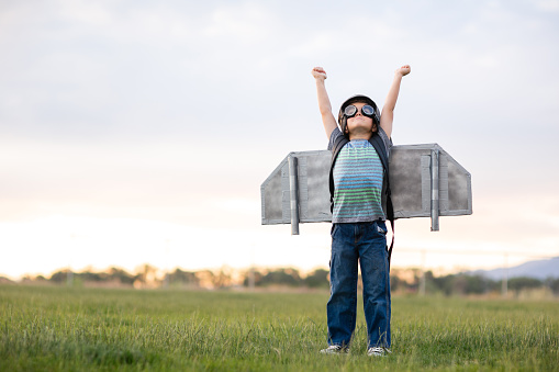 A young elementary aged boy imagines flying into the sky and accomplishing his dreams in a homemade jetpack. Image taken in Utah, USA.