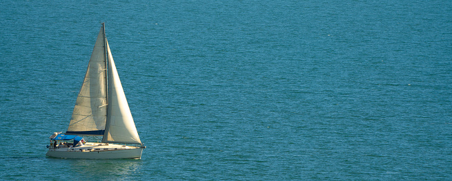White sailboat in blue sea
