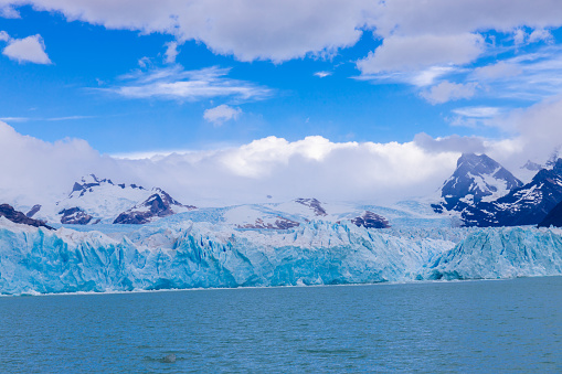 Perito Moreno sparkling glacier ice in Patagonia, Argentina Los Glaciers National Park near El Calafate. Bule ice South America mountains patagonian glacier on a sunny day with clouds. Glacier serac falling in lake