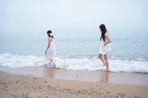 Two girls walking on the beach