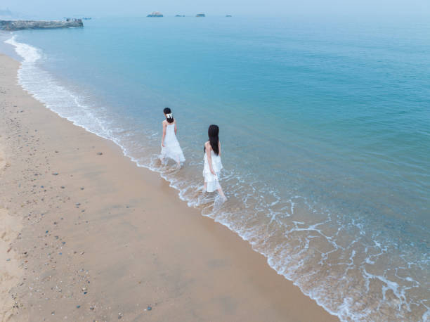 istock Two female tourists at the beach 2134199423