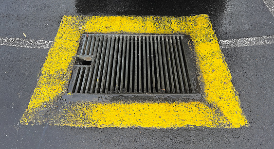 Abstract metal grate of water drain, storm drain, drain system with yellow square frame background.