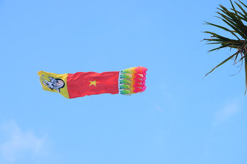 Can Tho, Vietnam 23, 2024: Flag kite flying in the clear blue sky in summer in Mekong Delta Vienam. Happy moments childhood.