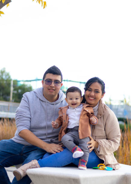 Happy family in a park, smiling and looking at camera in autumn