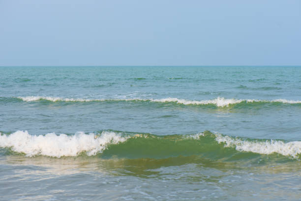 Bluewater waves on the surface ripples blurred. Defocus blurred transparent blue colored clear calm water surface texture with splash and bubbles. Water waves with shining pattern texture background.