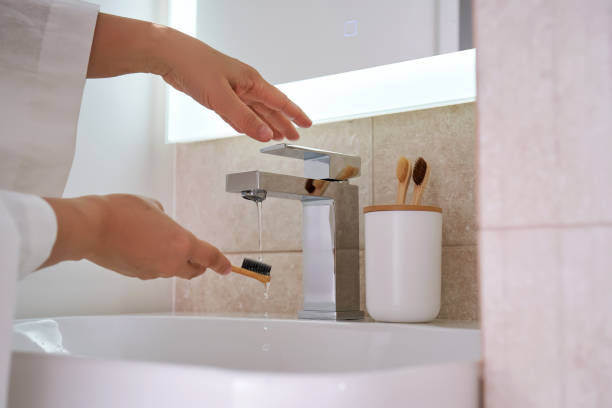 istock Women's hands under running water in the bathroom. Morning routine. 2134392220